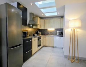 a kitchen with a stainless steel refrigerator and a lamp at Appartement 3 chambres - 100m2 - Jacuzzi in Les Deux Alpes