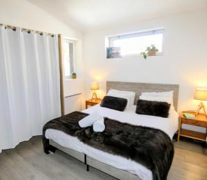 a bedroom with a large bed with black and white sheets at Appartement 3 chambres - 100m2 - Jacuzzi in Les Deux Alpes +9 photos