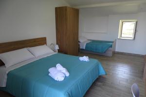 a bedroom with a blue bed with towels on it at MaMo B&B in Nocera Terinese