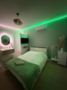 a bedroom with a bed with a green light at Le Sauge - Studio climatisé - Cocon rénové in Agen