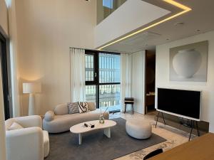 a living room with a couch and a tv at Caelum Black Gangnam Luxury Residence in Seoul