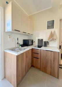 a kitchen with wooden cabinets and a sink at Irene Studios in Arillas +28 photos