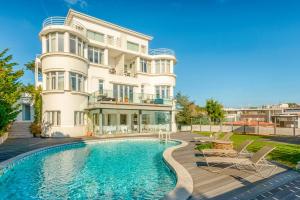 a house with a swimming pool in front of a building at Amazonia Estoril Hotel in Estoril