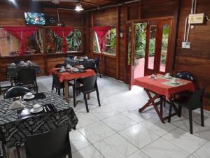 a dining room with red tables and chairs at Nomads Hostel in Puerto Iguazú