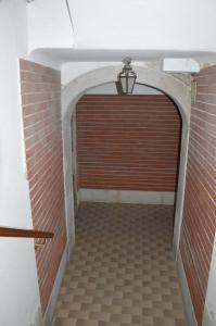 a tunnel with a brick wall and a wooden door at Dorso Duro Apartment in Venice
