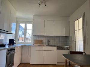 a kitchen with white cabinets and a table in it at 1 bed flat in central Zug in Zug