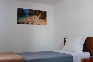 a bedroom with a bed and a picture of a beach at Vegas Residence - Adults Only in Albufeira