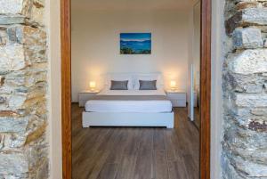 a bedroom with a white bed and two lamps at Ca da Smarè - Where Time stands Still in Someraro