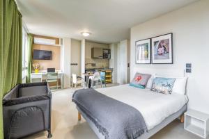 a bedroom with a bed and a living room at Appart'hôtel Toulouse Zénith in Toulouse