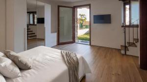 a bedroom with a white bed and a sliding glass door at Ca da Smarè - Where Time stands Still in Someraro