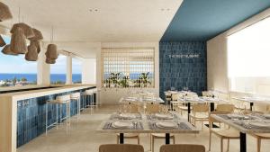 ein Restaurant mit Tischen und Stühlen und dem Meer in der Unterkunft Captains De Luxe in Argassi