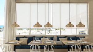 ein Esszimmer mit Tischen, Stühlen und Fenstern in der Unterkunft Captains De Luxe in Argassi