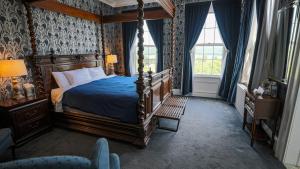 a bedroom with a canopy bed and blue wallpaper at Inn at Taughannock Falls in Ithaca
