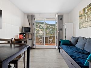 a living room with a blue couch and a table at Virginia N213 - 2p4 in Grasse