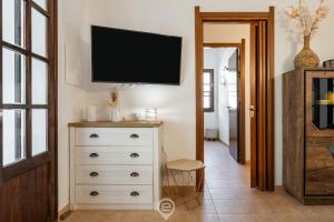 a room with a dresser with a tv on the wall at Estay - Casa Madili - Garden - BBQ - WiFi in Sarroch +44 photos
