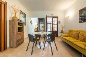 a living room with a table and a yellow couch at Estay - Casa Madili - Garden - BBQ - WiFi in Sarroch