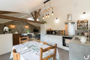 a kitchen and dining room with a table and chairs at Les Volets Bleus in Pointis-Inard