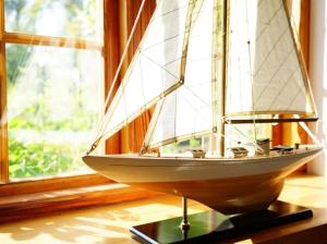 a model boat sitting on a table next to a window at Rosenhaus - Lütt Arnis in Arnis +15 photos