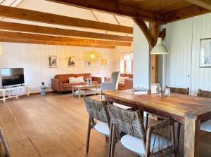 a dining room and living room with a wooden table and chairs at Rosenhaus - Lütt Arnis in Arnis