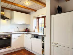 a kitchen with white cabinets and a window at Rosenhaus - Lütt Arnis in Arnis