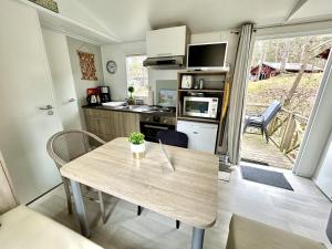 a small kitchen with a wooden table and a dining room at Tiny Home Strandkoje 823 in Göhren