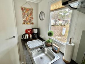 a kitchen sink in a kitchen with a window at Tiny Home Strandkoje 823 in Göhren +34 photos