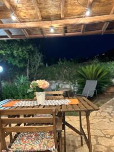 a wooden picnic table with a potted plant on it at Grace's Place in Scopello