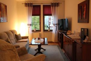 a living room with a couch and a tv at Pension La rose in Brandenburg an der Havel
