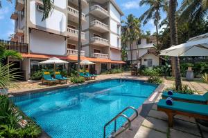 a swimming pool in front of a building at Radisson Goa Candolim in Candolim