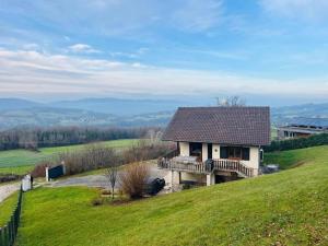 a house on top of a hill with a deck at Le chalet st hubert in Montcel