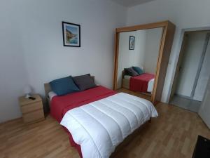 a bedroom with a large bed and a mirror at Appartement avec terrasse 53m2 in Saint-Martin-de-Valamas
