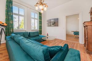 a living room with a blue couch and a table at Villa Tanneck App 1 in Ahlbeck