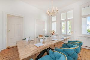 a dining room with a wooden table and blue chairs at Villa Tanneck App 1 in Ahlbeck