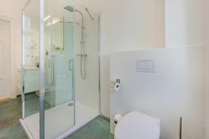 a bathroom with a glass shower and a toilet at Villa Tanneck App 1 in Ahlbeck +14 photos