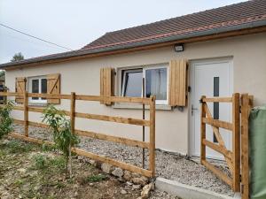 a house with a wooden fence in front of it at Maisonnette étape équestre in Nogent-lʼArtaud