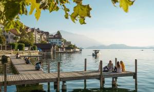 a group of people sitting on a dock on the water at 1 bed flat in central Zug in Zug