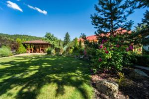 a yard with a gazebo and flowers at Villa Walir - Spa Hotel Garni SUPERIOR in Mariánské Lázně