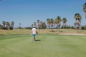 a man is playing golf on a golf course at Barceló Costa Ballena Golf & Spa in Costa Ballena