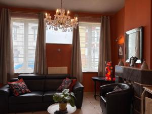 a living room with a couch and a chandelier at Au gîte de Binche in Binche