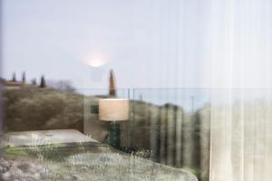 a lamp sitting on a table next to a window at Villa La Biancolilla in Garda