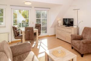 a living room with a couch and a tv at Ayuna in Langeoog