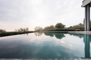 a pool of water next to a house at Villa La Biancolilla in Garda