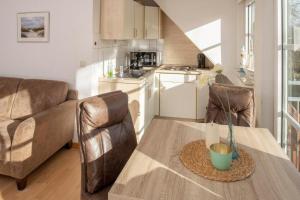 a kitchen with a table and a couch and a table at Ayuna in Langeoog