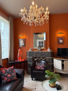 a living room with a fireplace and a chandelier at Au gîte de Binche in Binche