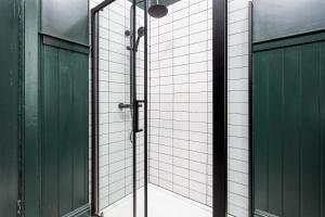 a bathroom with a shower with green doors at The Fairlie Suite No1 in Prestwick