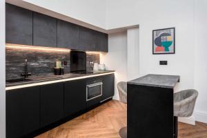 a kitchen with black cabinets and a counter top at The Fairlie Suite No1 in Prestwick