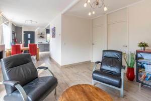 a living room with a couch and a chair and a tv at Californiëweg 9A in De Koog