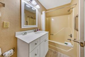 a bathroom with a white sink and a shower at 2 Bedroom Condo on Lake with Jacuzzi in New Bern