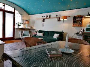 a living room with a table and a green couch at Peter 7 Altstadt - Dachstudio & Peter 7 Altstadt - Erdgeschoss mit Gartenblick in Görlitz