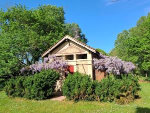 a small house with purple wisterias in front of it at l'ancienne gare in Gamarde-les-Bains